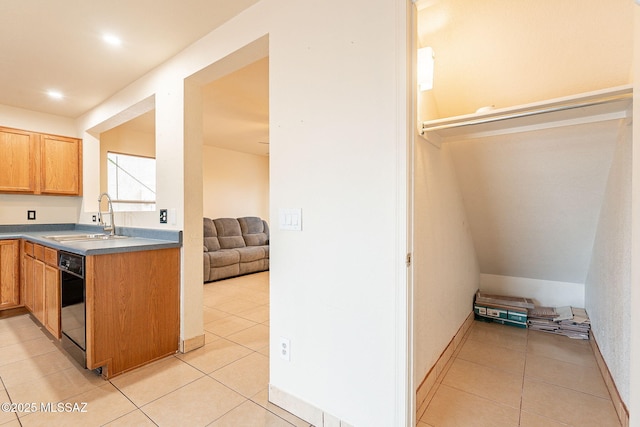 kitchen with dishwasher, open floor plan, light tile patterned flooring, and a sink