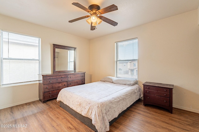 bedroom featuring light wood-type flooring, ceiling fan, and baseboards