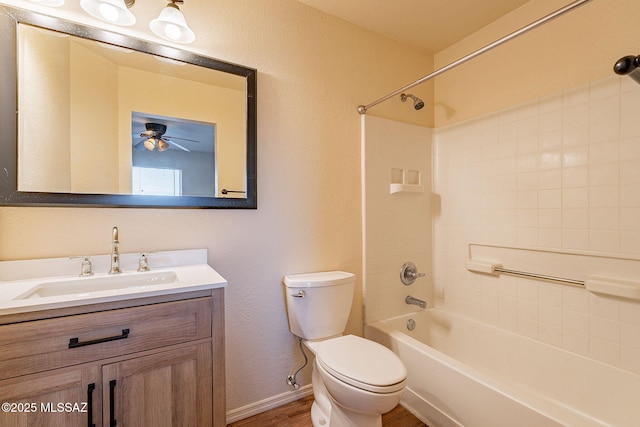 bathroom with toilet, ceiling fan, vanity,  shower combination, and baseboards