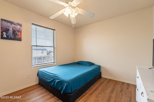 bedroom with light wood-type flooring, ceiling fan, and baseboards