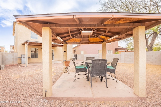 view of patio / terrace with grilling area, a fenced backyard, outdoor dining area, and a gazebo