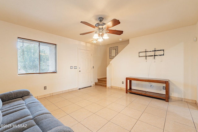 living room with ceiling fan, stairway, and light tile patterned floors