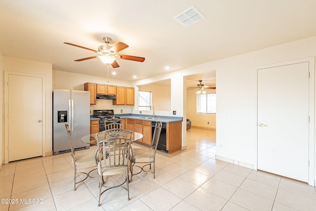 kitchen with visible vents, under cabinet range hood, black appliances, and light tile patterned floors