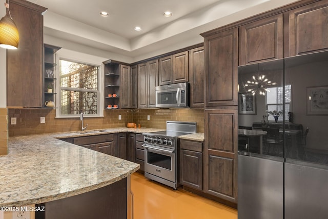 kitchen with dark brown cabinetry, appliances with stainless steel finishes, open shelves, and light stone counters