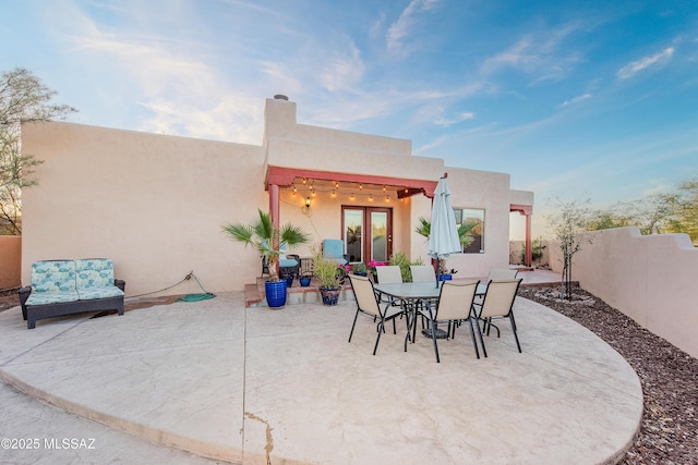 view of patio / terrace with french doors, outdoor dining space, and fence