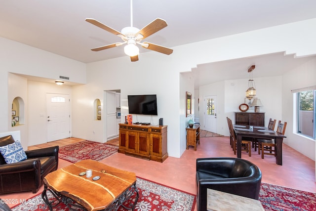 living area with ceiling fan, vaulted ceiling, and visible vents