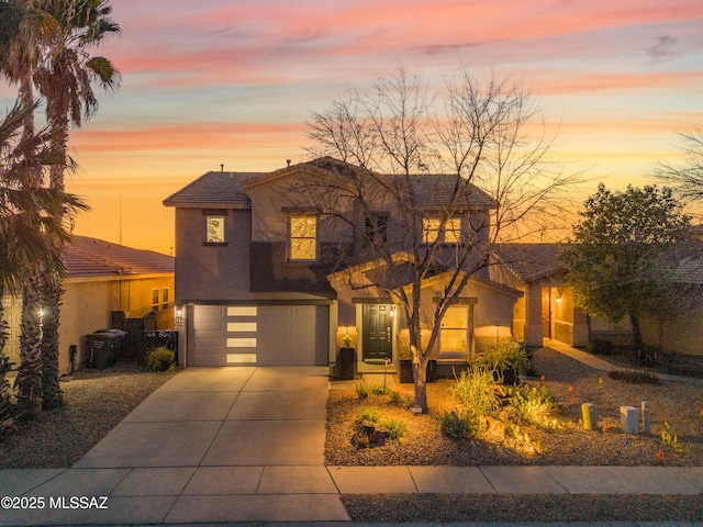 view of front of home featuring driveway, an attached garage, and stucco siding