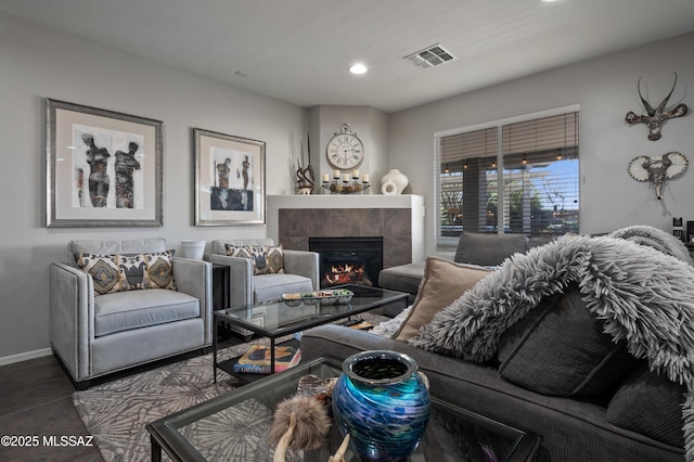 living room with recessed lighting, a tiled fireplace, visible vents, and baseboards