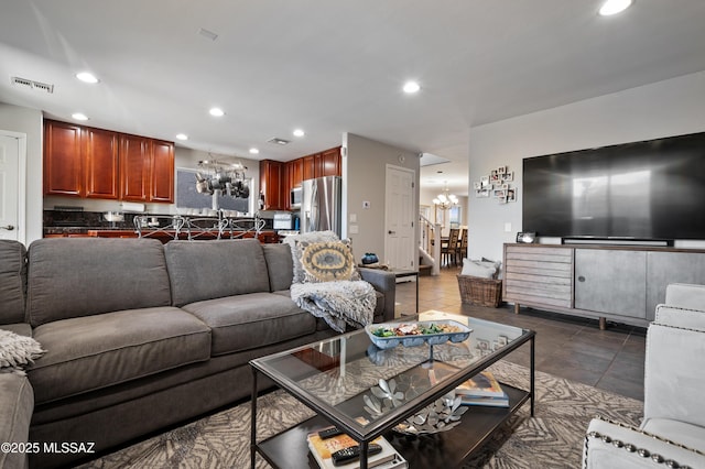 living room featuring recessed lighting, visible vents, dark tile patterned flooring, and an inviting chandelier