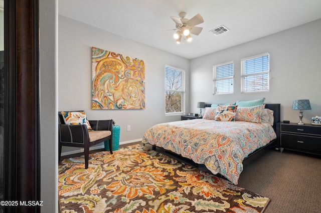 carpeted bedroom with a ceiling fan, visible vents, and baseboards