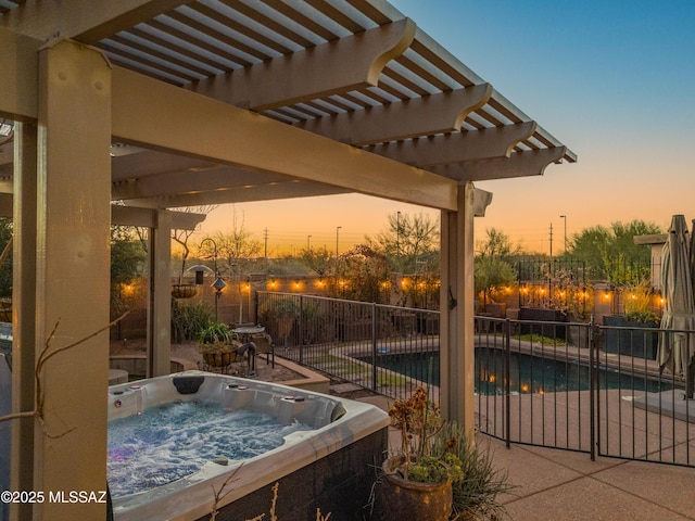 patio terrace at dusk featuring an outdoor hot tub, fence, and a pergola