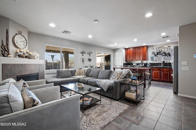 living area with recessed lighting, visible vents, and a tile fireplace