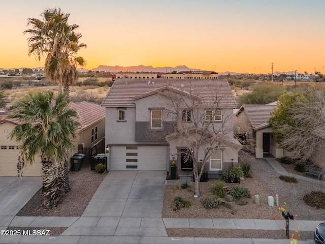 view of front of property with a garage, a tile roof, driveway, and stucco siding