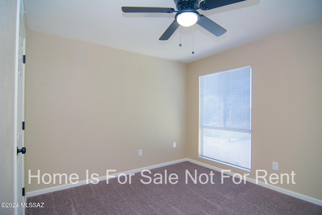 spare room with carpet, a ceiling fan, and baseboards