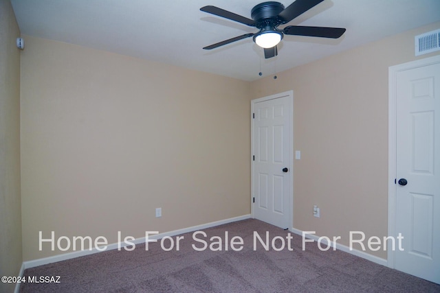 spare room with carpet floors, baseboards, visible vents, and ceiling fan