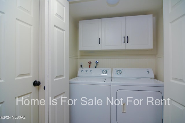 clothes washing area with cabinet space and washing machine and clothes dryer