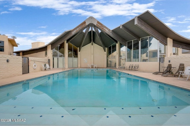 pool with a patio and fence