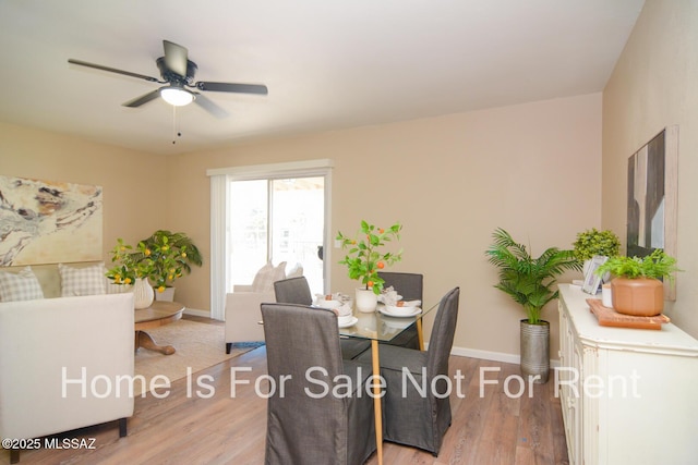 dining area featuring light wood-type flooring, baseboards, and a ceiling fan