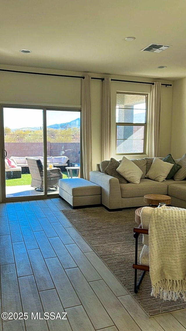 unfurnished living room featuring wood tiled floor and visible vents