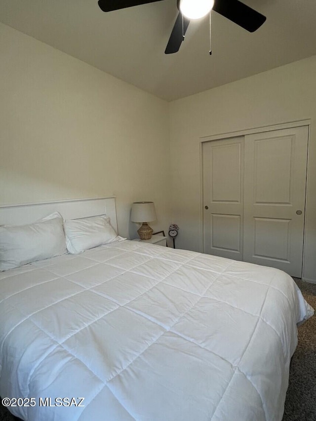 carpeted bedroom featuring a ceiling fan and a closet