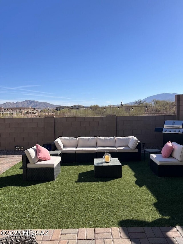 view of yard featuring an outdoor hangout area, a fenced backyard, and a mountain view