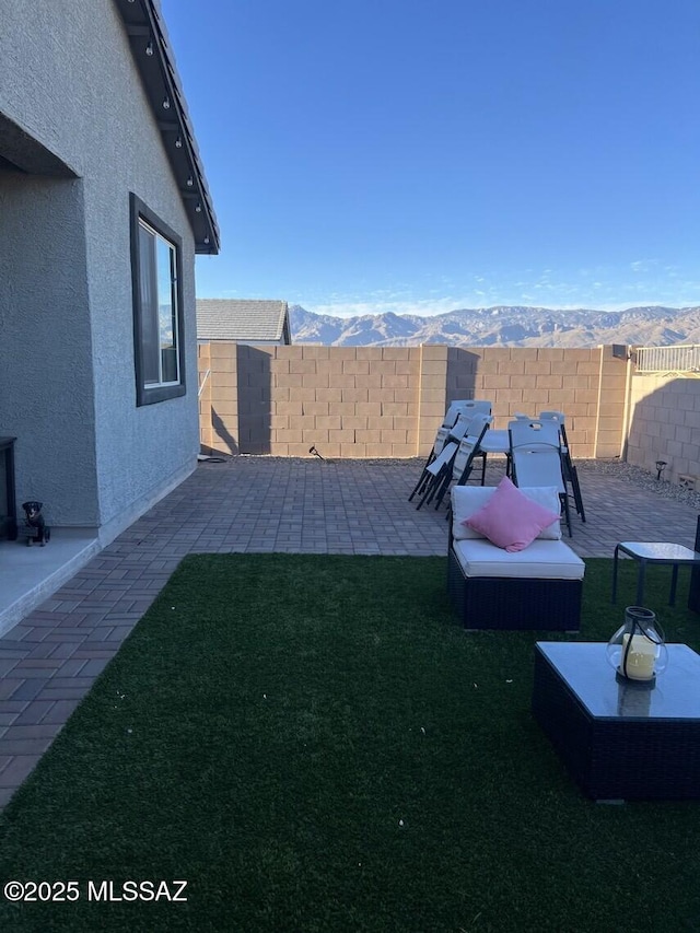 view of yard with a patio area, a fenced backyard, and a mountain view