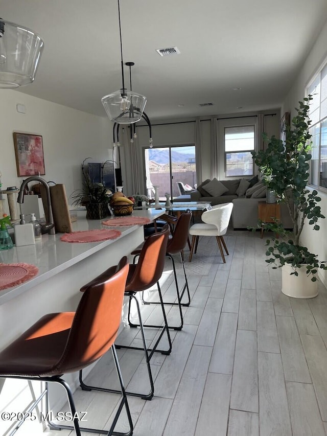 dining space featuring visible vents, plenty of natural light, and light wood finished floors