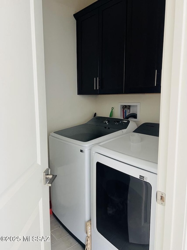 clothes washing area featuring washing machine and clothes dryer and cabinet space