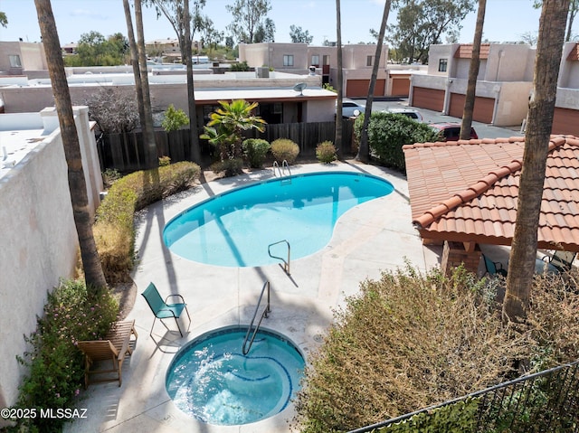 view of swimming pool featuring a patio area, a fenced backyard, a fenced in pool, and a hot tub