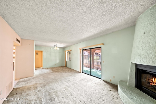 unfurnished living room with carpet, visible vents, a textured ceiling, and a high end fireplace