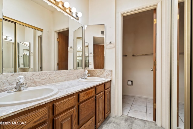 full bathroom featuring double vanity, visible vents, a sink, and tile patterned floors