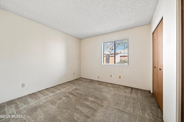 empty room featuring carpet floors and a textured ceiling