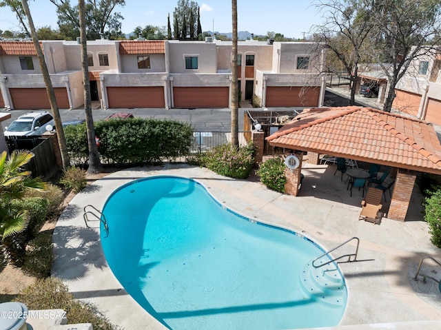 pool with a patio and fence