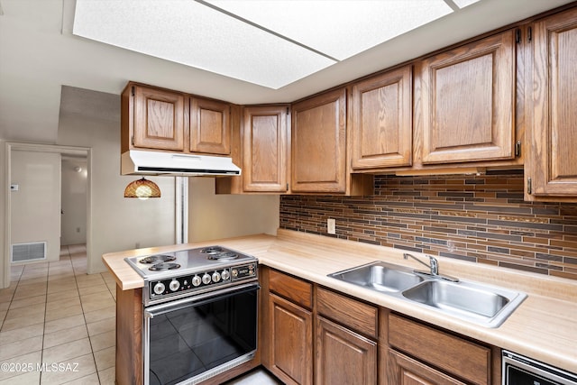 kitchen with visible vents, electric stove, under cabinet range hood, a sink, and light tile patterned flooring