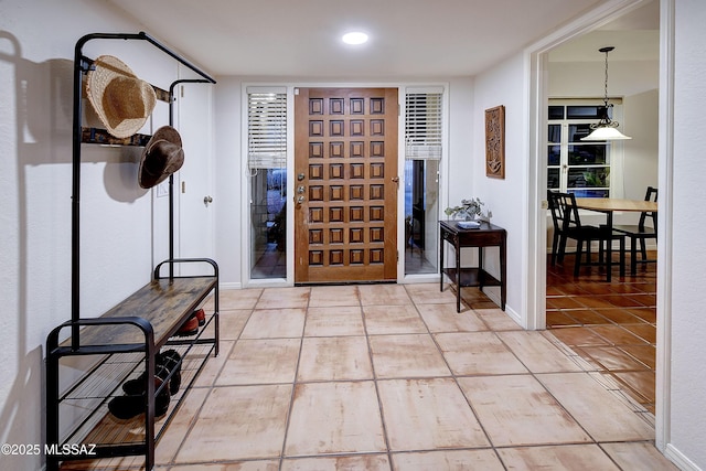 foyer featuring baseboards and tile patterned floors