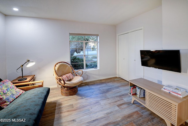 living area with recessed lighting, baseboards, and wood finished floors