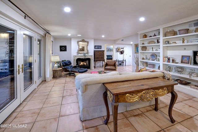 living area with recessed lighting, french doors, a lit fireplace, and light tile patterned floors