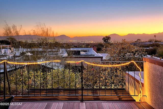 balcony at dusk featuring a mountain view