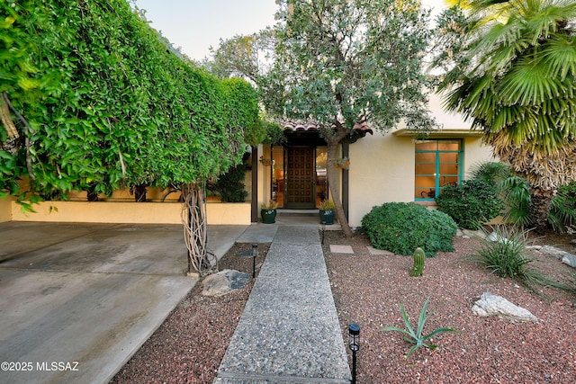 view of front facade featuring a tiled roof and stucco siding