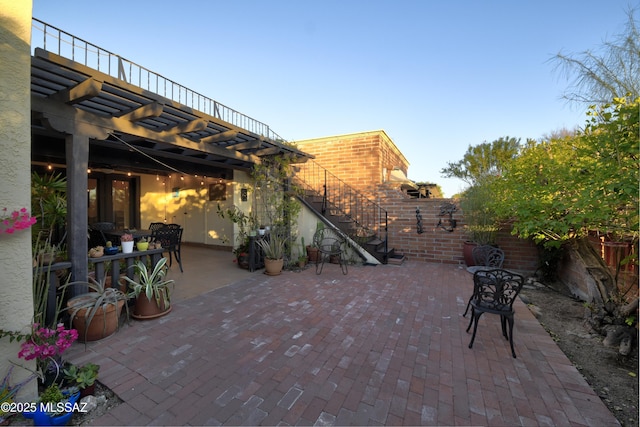 view of patio with stairs, fence, and a pergola