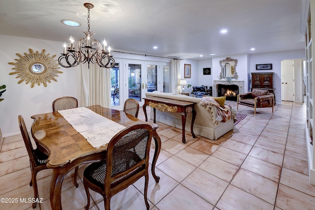 dining space with a warm lit fireplace, light tile patterned floors, french doors, a chandelier, and recessed lighting