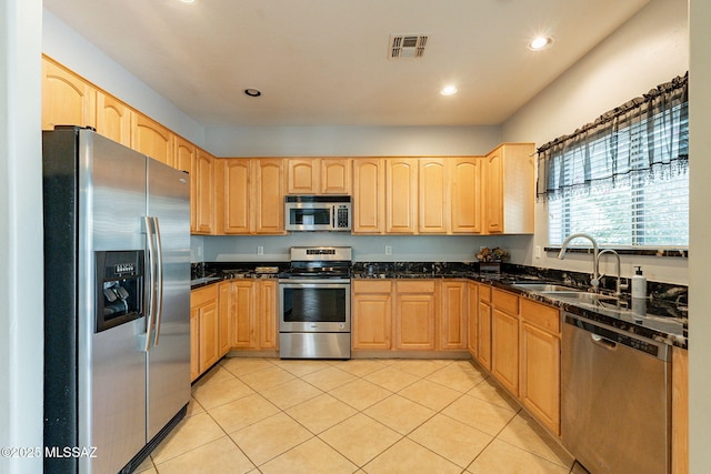 kitchen featuring visible vents, stainless steel appliances, a sink, and light brown cabinetry