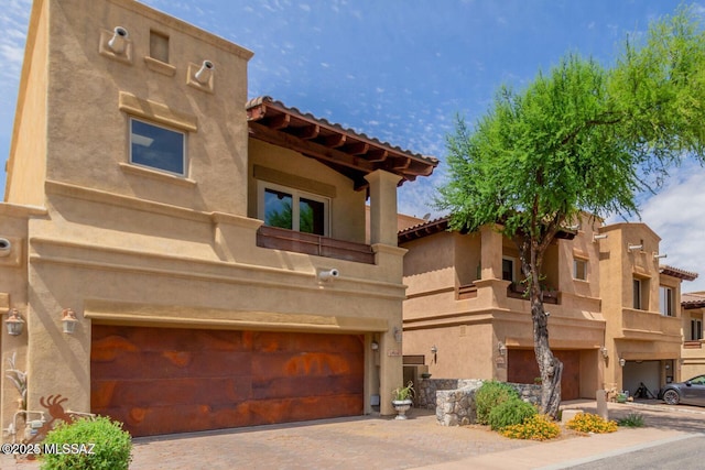 view of property with a garage and decorative driveway