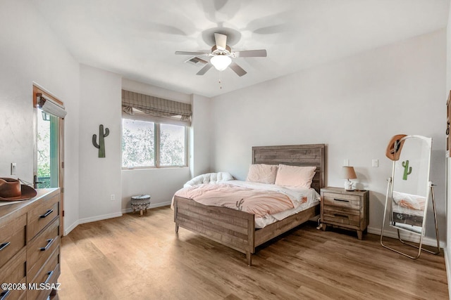 bedroom with ceiling fan, light wood finished floors, visible vents, and baseboards