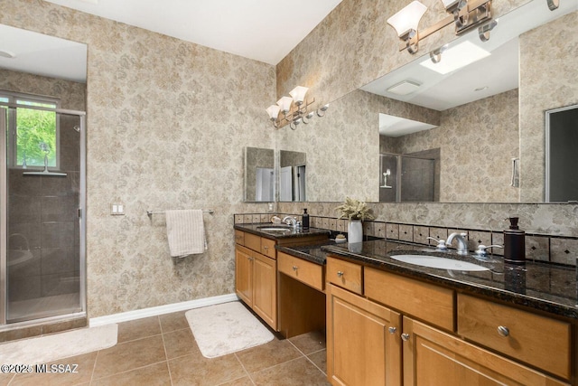 bathroom with double vanity, tile patterned flooring, a shower stall, and a sink