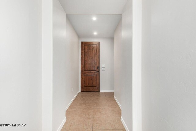 hall with light tile patterned floors, baseboards, and recessed lighting