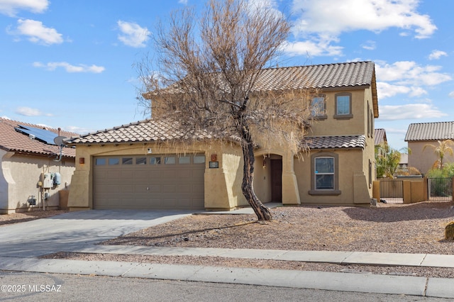 mediterranean / spanish-style home with concrete driveway, an attached garage, a tile roof, and stucco siding