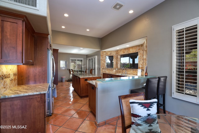 kitchen with visible vents, decorative backsplash, a sink, and light tile patterned flooring