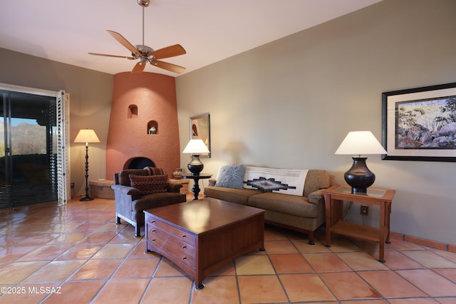 living area featuring light tile patterned flooring, a ceiling fan, and baseboards