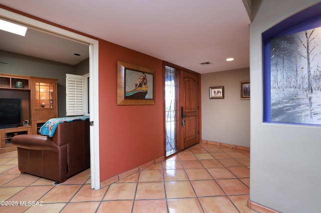 entryway with light tile patterned flooring, visible vents, and baseboards